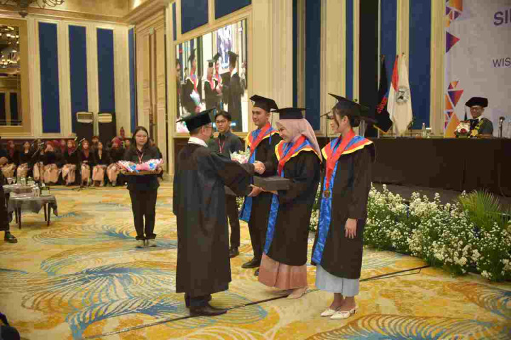Ketua Stikom Bandung Dr Dedy Jamaludin Malik, M.Si menyerahkan penghargaan kepada lulusan terbaik pada Wisuda Gelombang X di Hotel Papandayan, Sabtu (14/2/2026)